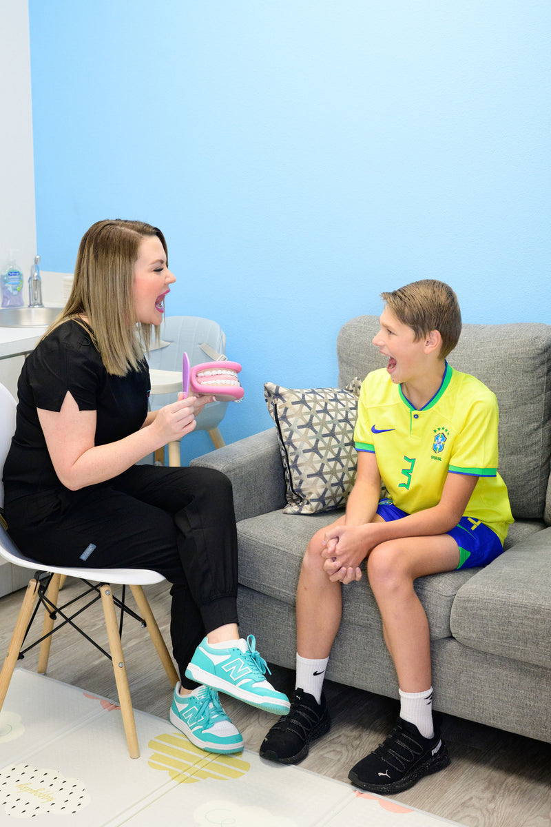 Meagan using a mouth model to teach oral posture to a school-age boy