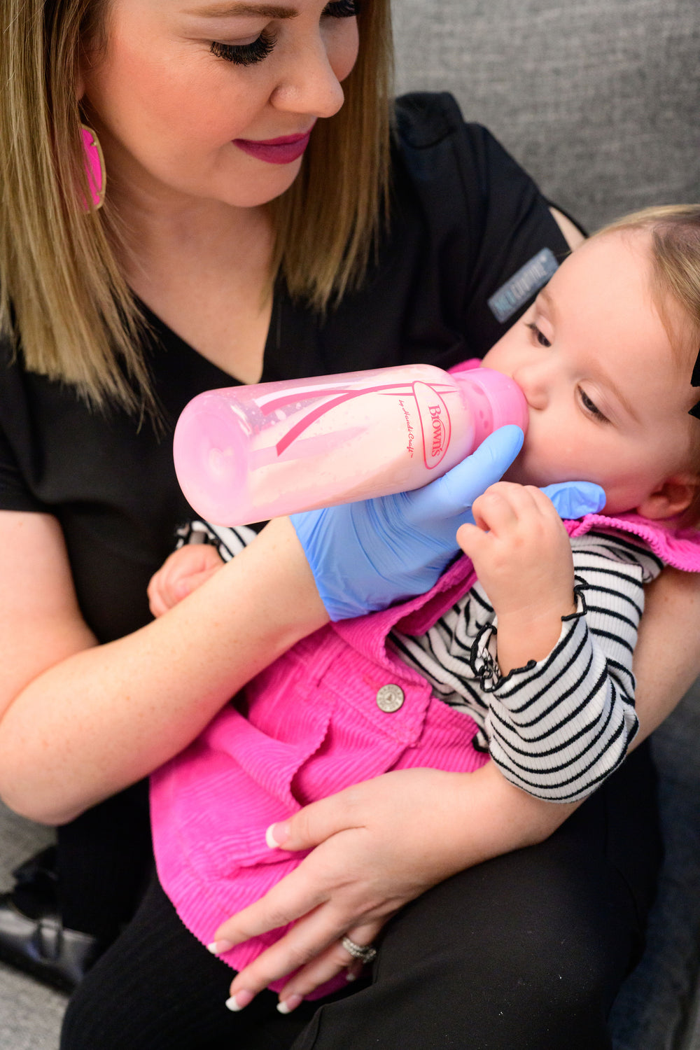 Meagan supporting a toddler during a bottle feeding session